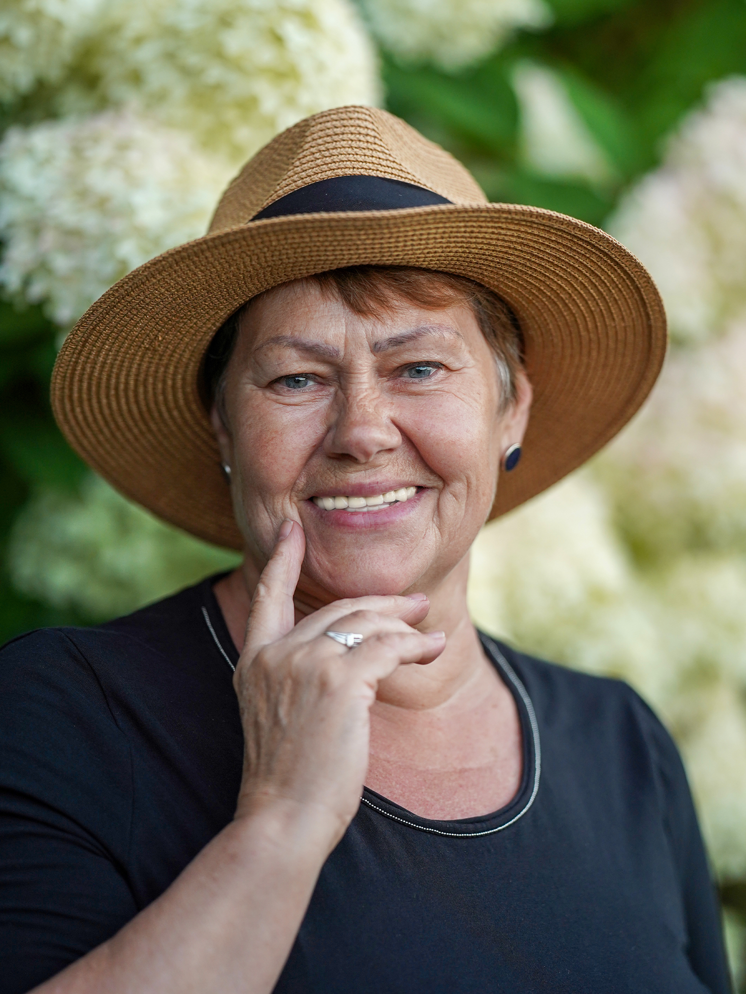 mid-aged woman in a hat smiling