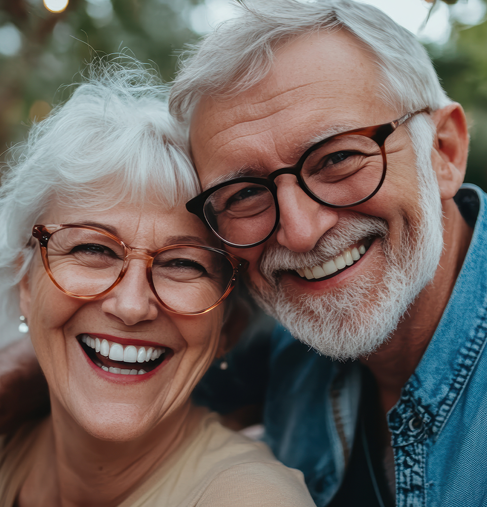 older man and woman smiling wearing glasses